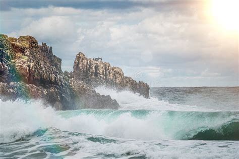 Ocean Water Splash On Rock Beach With Beautiful Sunset Sky And Clouds