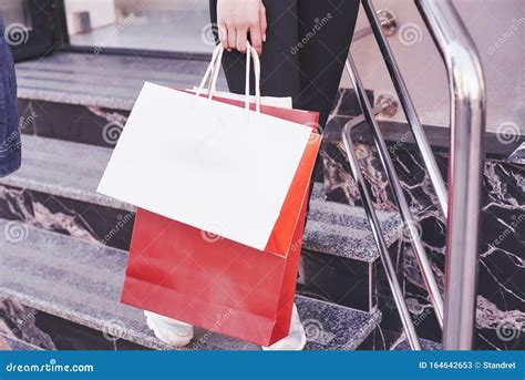 Close Up Young Woman Carrying Shopping Bags While Walking On The Stairs After Visiting The