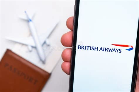 British Airways App Logo On The Screen Of Mobile Phone A Blurry Image Of A Plane A Passport