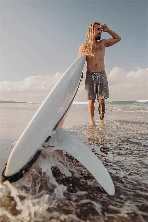 A Guy Is Standing On The Beach Looking At The Waves Del Colaborador