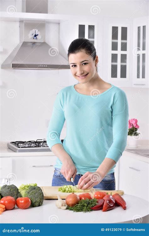 Femme Faisant Cuire Dans La Cuisine Neuve Effectuant La Nourriture Saine Avec Des Légumes Image