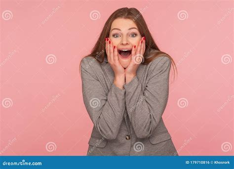 Portret Van Een Verbaasde Jonge Brunette Vrouw In Een Pak Dat Handen In Het Gezicht Houdt En