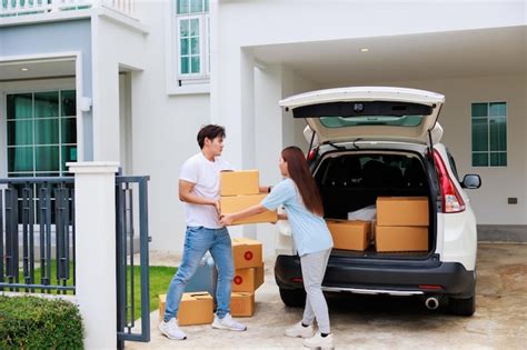 Feliz casal aisan ajuda a mover caixas de papelão para a nova casa