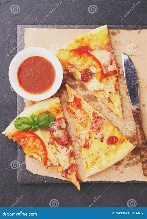 Pizza With Sausage Ham Tomato And Cheese Decorated With Basil And