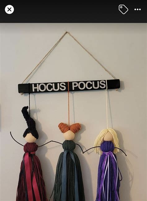 Three Tassels Hanging On A Wall With The Word Hoccus Pocus Above Them