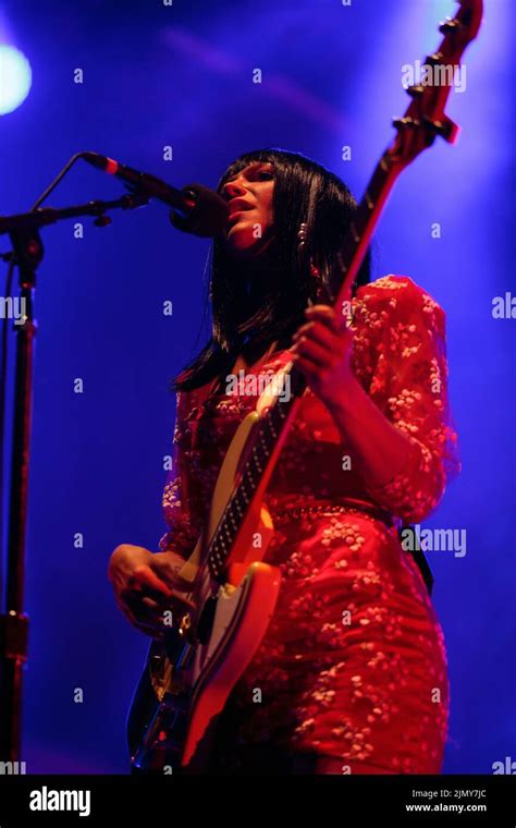 Bassist Laura Lee Of Khruangbin On Stage Wearing A Red Floral Mini Dress With White Stockings