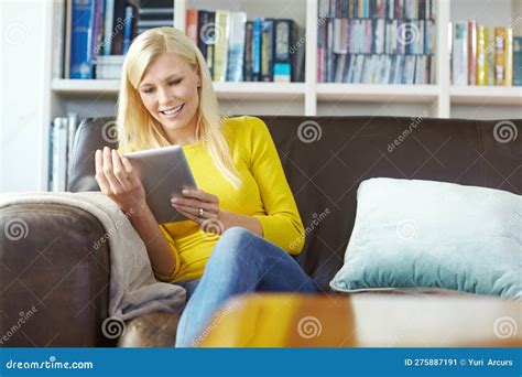 Beautiful Young Happy Woman Sitting On The Sofa Holding And Using A