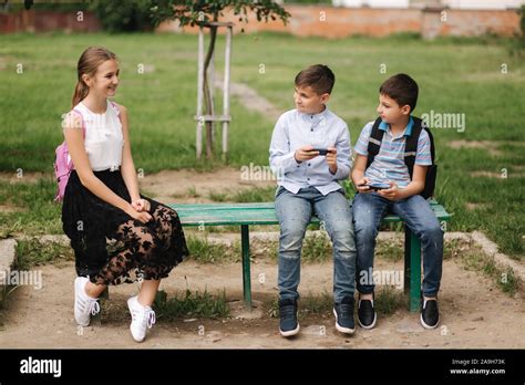 Two Boys And Girl Use Their Phones During School Breack Cute Boys