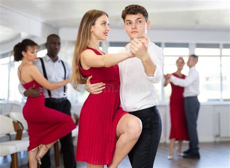 Guy Dancing Merengue With Female Partner In Red In Dance Class Stock