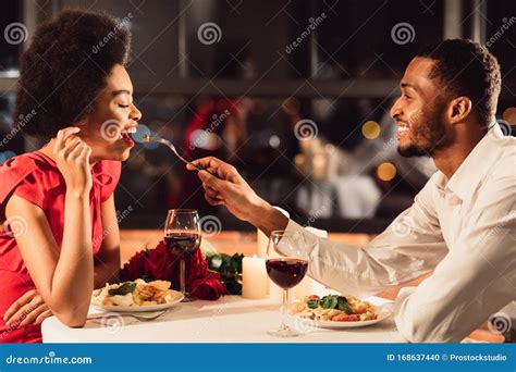 African American Man Feeding Girlfriend Celebrating Anniversary In