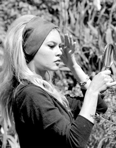 a woman looking through a magnifying glass in the woods while wearing a head scarf