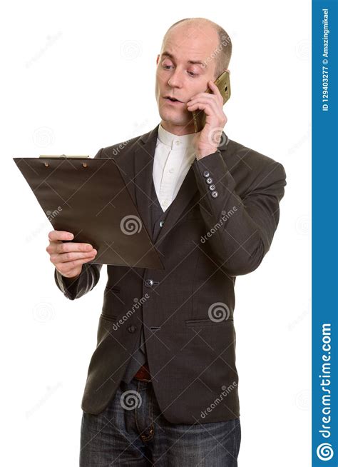 Bald Caucasian Businessman Reading On Clipboard While Talking On Stock