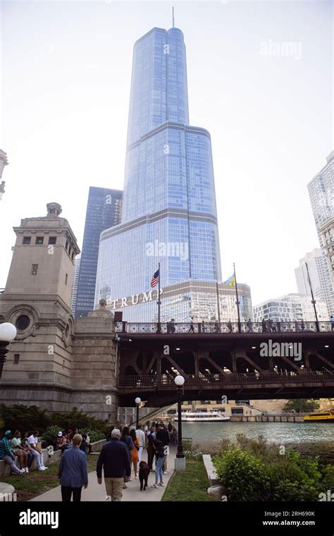 People By The Chicago Riverwalk Near Dusable Bridge With Trump Tower In