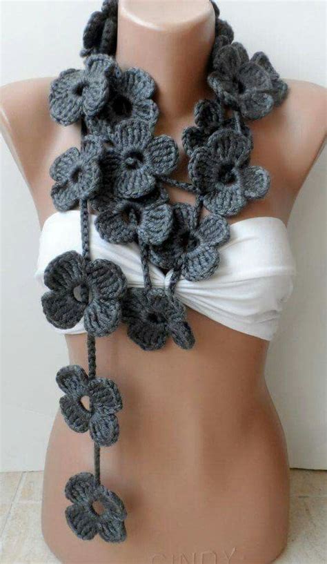 A Gray Crocheted Flower Scarf On A Mannequin Headpiece With White Tank Top