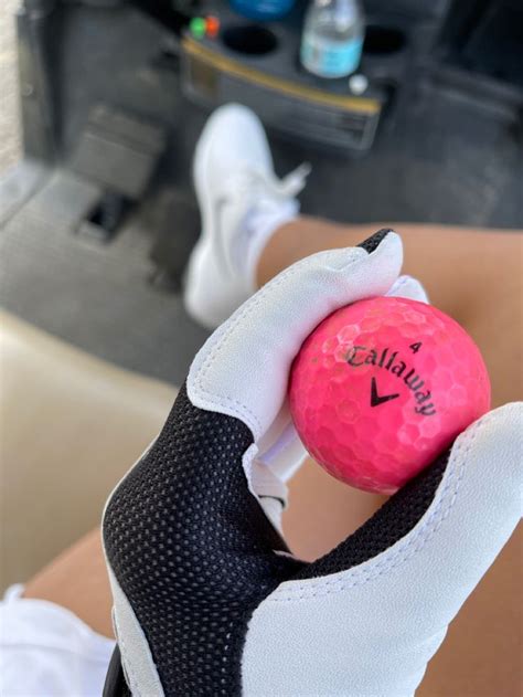 A Person Holding A Pink Golf Ball In Their Left Hand With The Word