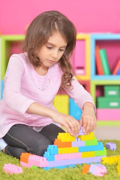 Niña jugando con coloridos bloques de plástico Foto Premium