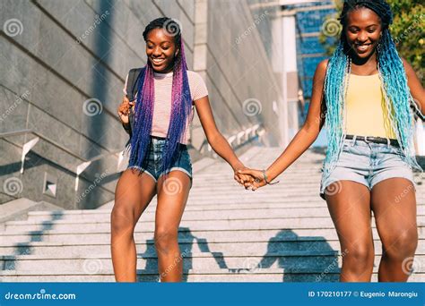 Two Beautiful Young Black Sisters Walking Downstairs Together Holding Hands Stock Image Image