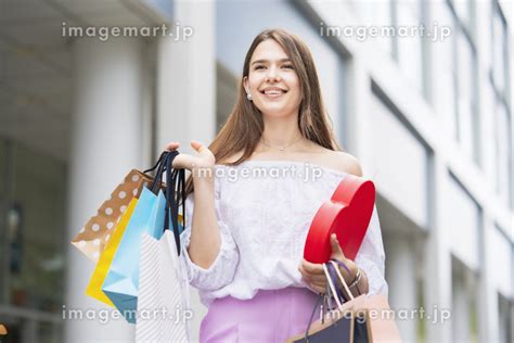 たくさんの買い物袋を抱える女性の写真素材 131333788 イメージマート