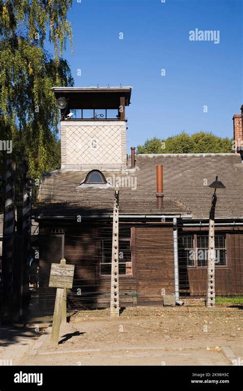 Valla de alambre de púas y edificio con una torre de guardia dentro del