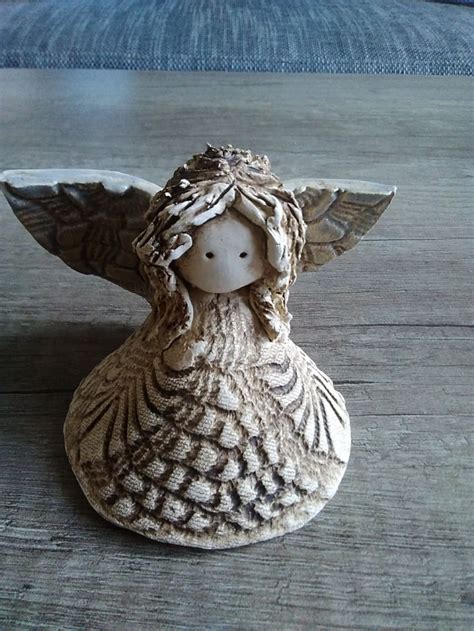 An Angel Figurine Sitting On Top Of A Wooden Table