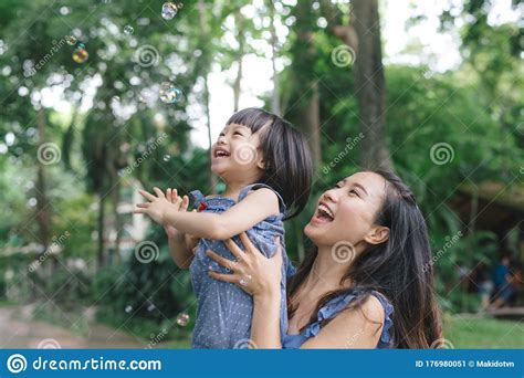 Portrait De Petite Fille Treignant Sa Maman Avec La Nature Et La Lumi