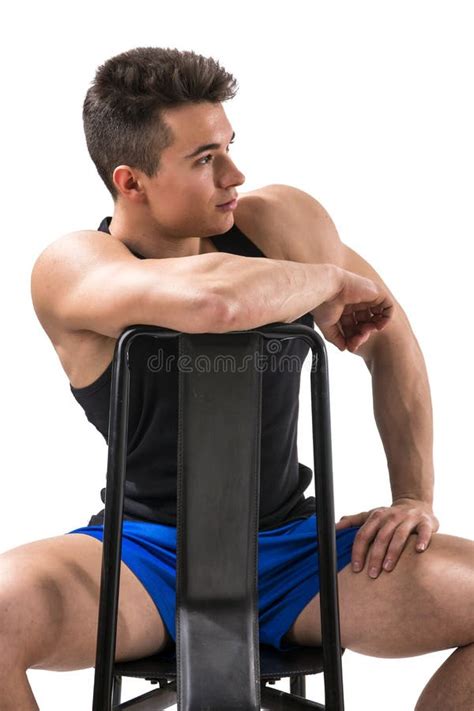 Hombre Muscular Joven Hermoso Que Se Sienta En Silla Imagen De Archivo