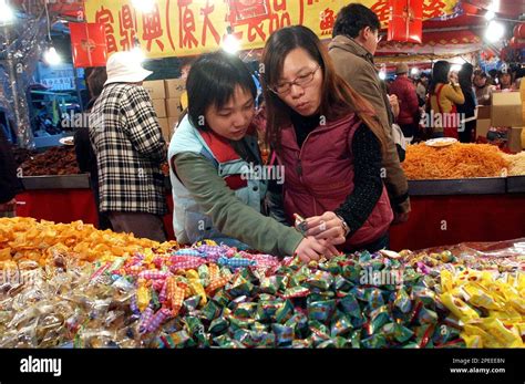 Two Shoppers Sample Sweets As They Shop In The Famed Dihua Street Ahead