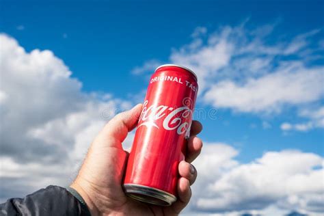 Hand Holding A Coca Cola Can Towards Beautiful Mountain Scenery