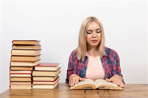 Jeune Femme Assise Avec Des Livres Et Lisant Sur Blanc Photo Gratuite