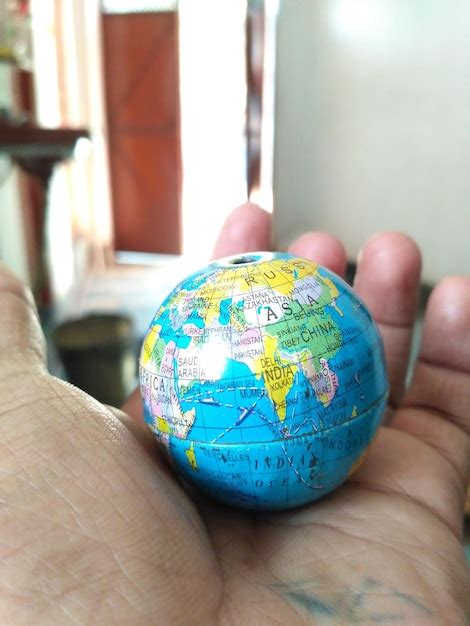 Premium Photo Cropped Hand Holding Globe