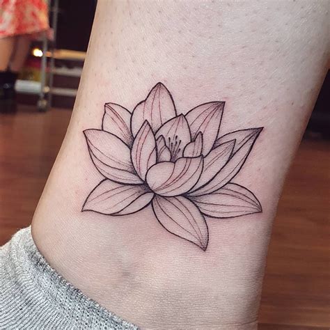 A Black And White Lotus Tattoo On The Ankle