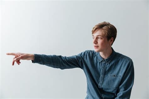 Premium Photo Smiling Young Man Pointing Away