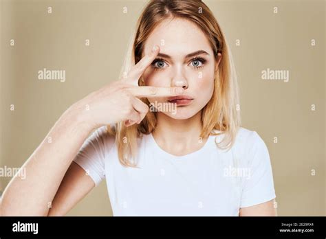 Cheerful Blonde Woman In A White T Shirt Gestures With Her Hand