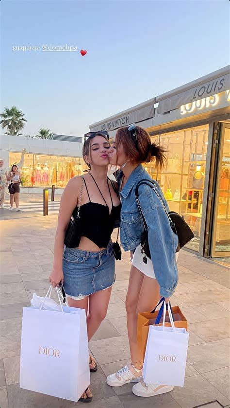 Two Women Kissing Each Other While Holding Shopping Bags