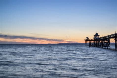 Beautiful Long Exposure Sunset Over Ocean With Pier Silhouette Stock