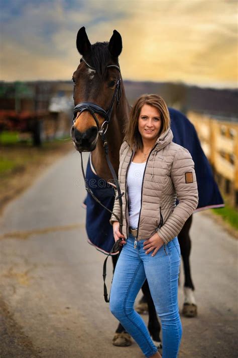 Woman With Horse In Portraits On A Path With Dramatic Sky In The