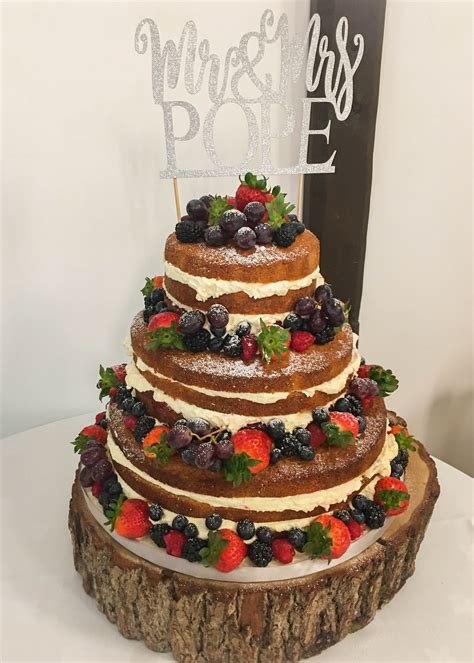 Fully Naked Wedding Cake Oozing With Layers Of Buttercream And Fresh Fruit Adorning Each Tier