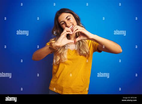 Young Beautiful Woman Wearing Yellow T Shirt Over Blue Isolated