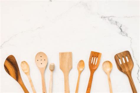 Wooden Spoons And Spatulas Lined Up On A Marble Surface