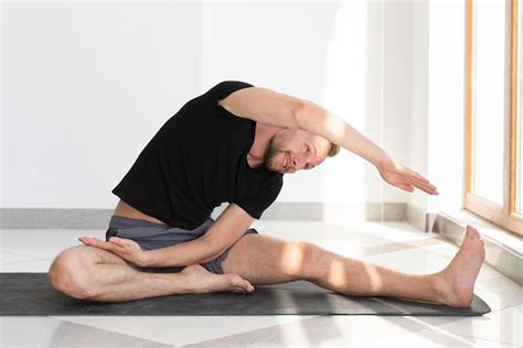 Free Photo Full Shot Man Stretching On Yoga Mat Indoor