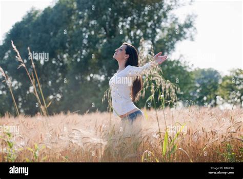 Woman With Arms Stretched Out In Wheat Field Stock Photo Alamy