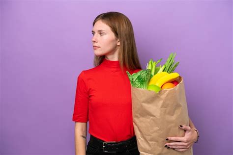 Jovem Inglesa Segurando Uma Sacola De Compras Isolada Em Fundo Roxo