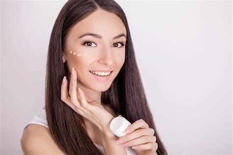 Premium Photo Beautiful Woman Applying Cosmetic Face Cream