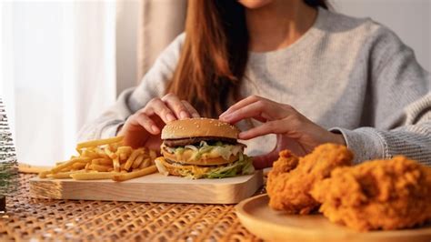 Premium Photo Closeup Image Of A Woman Holding And Eating Hamburger