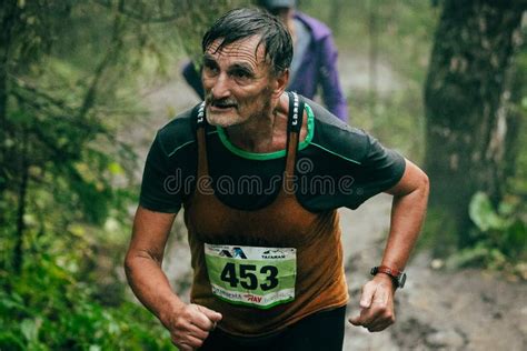 Two Elderly Joggers Run Along Embankment Of River Editorial Stock Photo