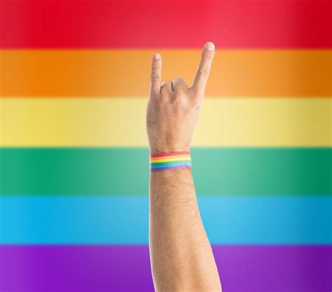 Premium Photo Hand With Gay Pride Rainbow Wristband Shows Rock