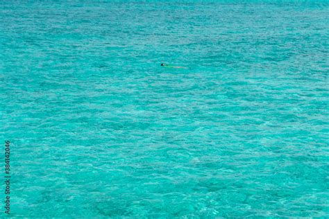 Girl In Vivid Color Swim Suit Snorkeling Alone Isolated In Waters Of