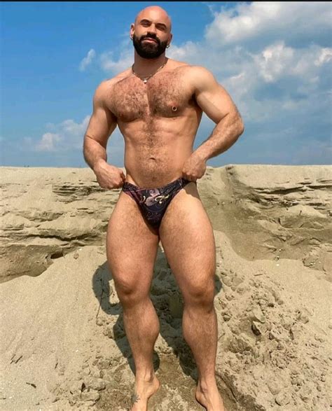 A Man With No Shirt Standing In The Sand