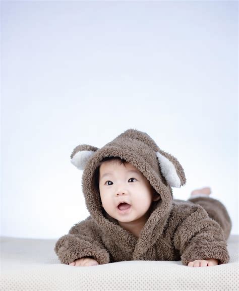 Adorable bebé sonriendo vistiendo traje de oso pardo Foto Premium