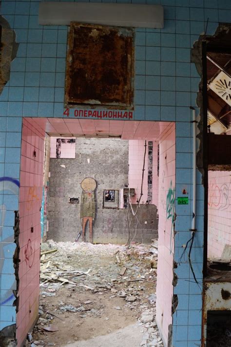 An Abandoned Bathroom With Graffiti On The Walls And Peeling Paint All